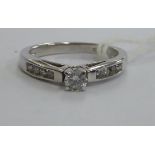 A white gold coloured metal single stone claw set diamond ring 11