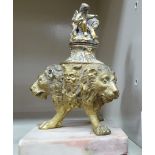 A mid 20thC cast gilt metal inkwell, the lid fashioned as a cherub seated beside a lion,