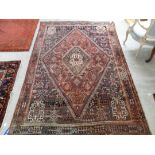 A Persian rug, decorated with stylised designs,