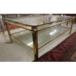 A modern brass framed coffee table with two tier glass shelves,