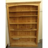 A modern honey coloured pine open front bookcase with a level cornice,