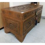 A 20thC Chinese carved hardwood chest with straight sides and a hinged lid,