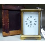 An early 20thC carriage timepiece with bevelled glass panels and a folding top handle,