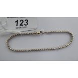 A Dorica white coloured gold ball cut bead bracelet,