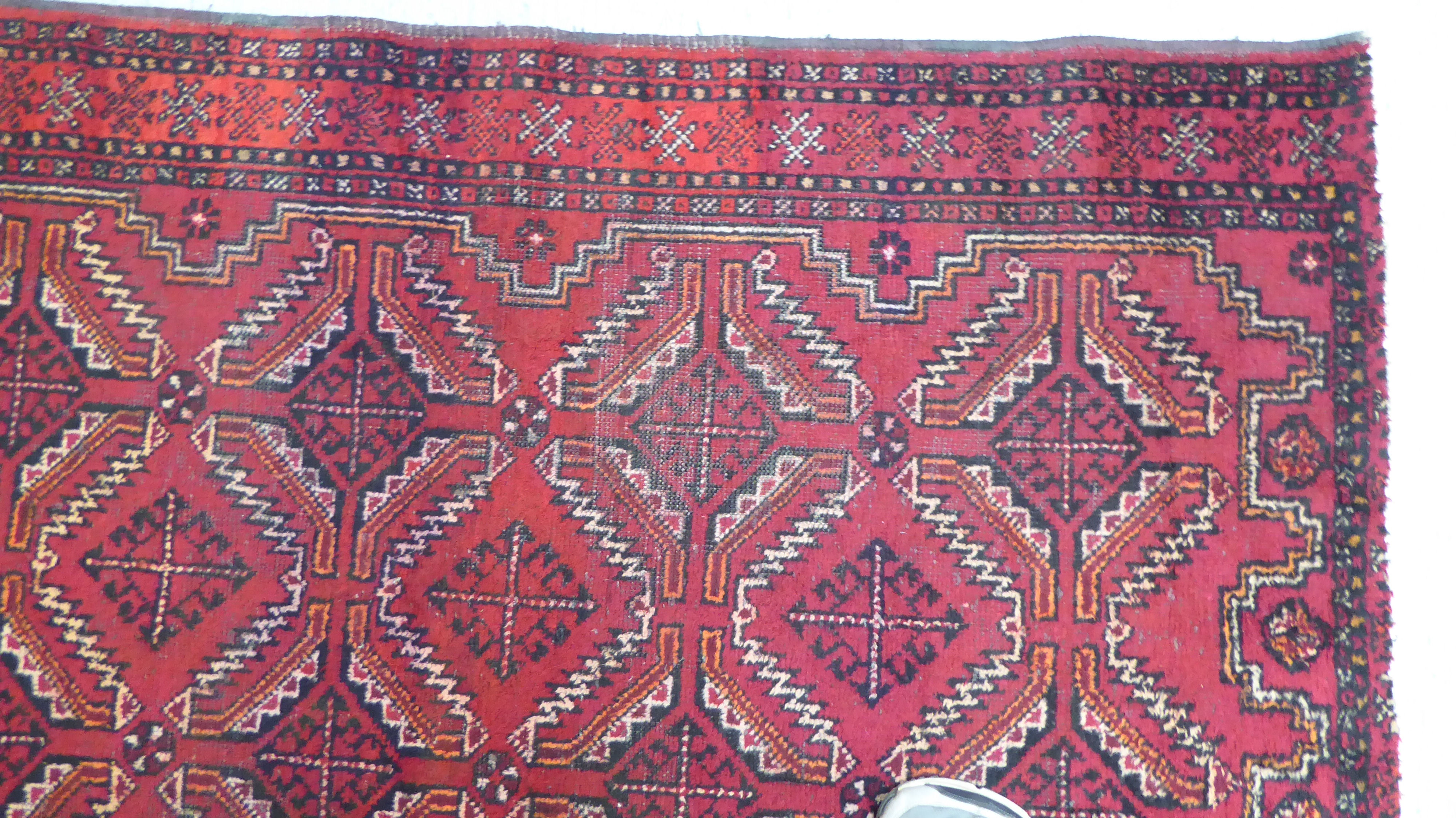 A Turkoman rug, decorated with two columns of four diamond motifs, bordered by stylised designs, - Image 2 of 3