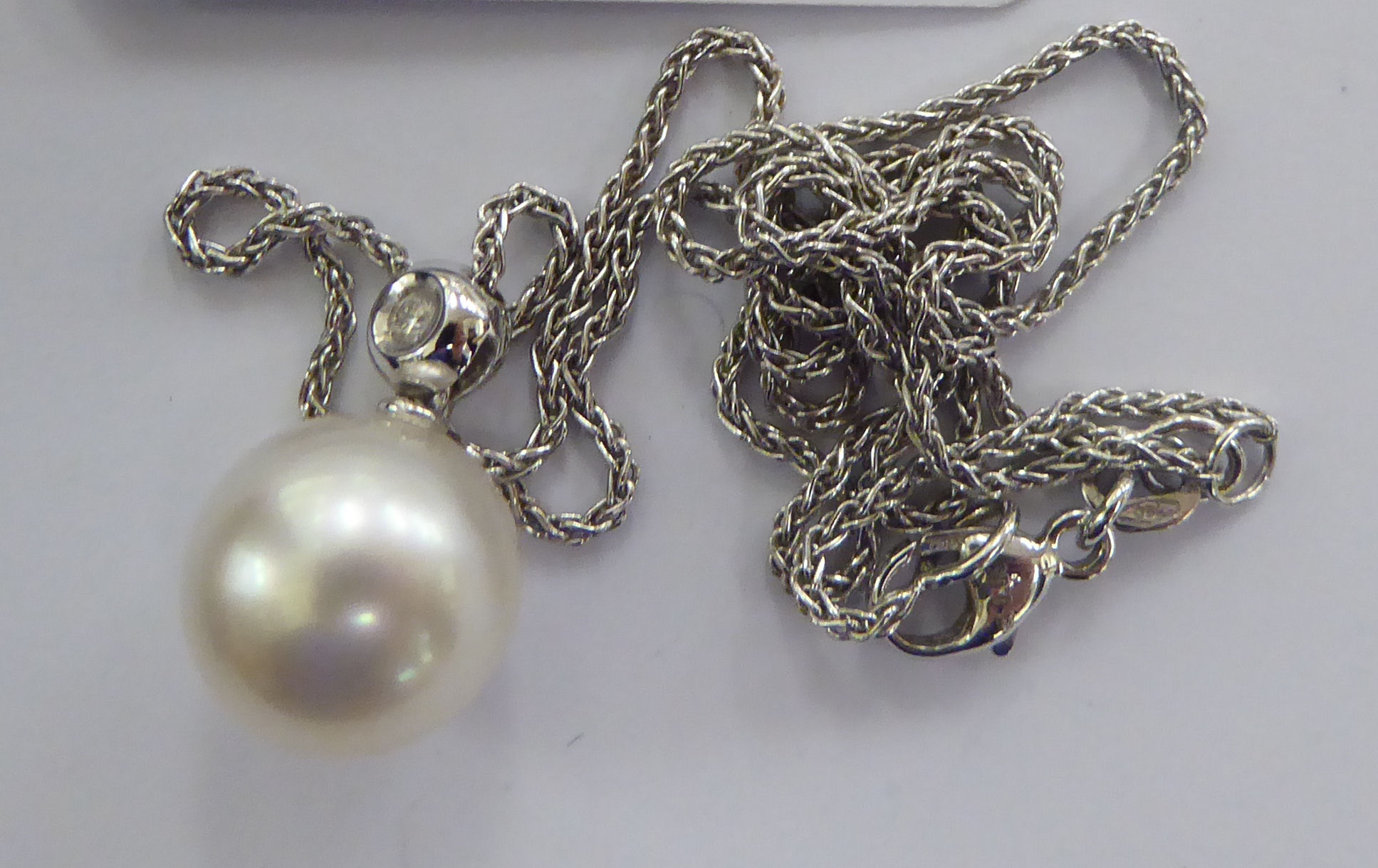 An 18ct white gold mounted, single pearl and diamond set pendant,