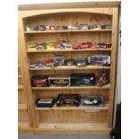 A modern honey coloured pine open front bookcase with a level cornice,