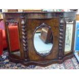 A late Victorian walnut serpentine front chiffonier with a central mirrored door,