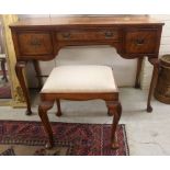 A mid 20thC string and ebony inlaid burr walnut finished, three drawer kneehole dressing table,