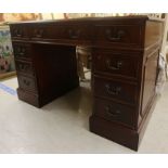 A modern reproduction mahogany, nine drawer, twin pedestal desk,