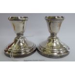 A pair of silver dwarf candlesticks, each with a vase shaped socket,