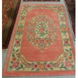 A Chinese washed cotton rug, decorated with flora, in pastel tones,