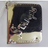 A silver postage stamp box, fashioned as a book with a rotating cover,