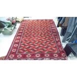 A Turkoman carpet, decorated with repeating stylised designs,