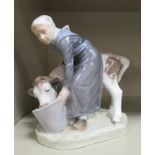 A Royal Copenhagen porcelain figure, a milkmaid with a cow, drinking from a pail no.779 7.