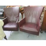 A pair of modern 'vintage' style wingback chairs, having enclosed arms,