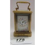A modern miniature French 'antique' inspired brass cased carriage timepiece with three porcelain