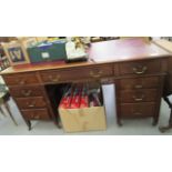 An early 20thC fielded, panelled mahogany twin pedestal desk, the top having a maroon hide scriber,