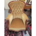 A late Victorian walnut showwood framed and carved spoonback chair with enclosed arms,