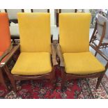 A pair of 1970s teak easy chairs, upholstered in yellow fabric with swept open arms,