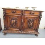 A late Victorian oak dresser base profusely carved with hounds heads, wild boar, game and fish,