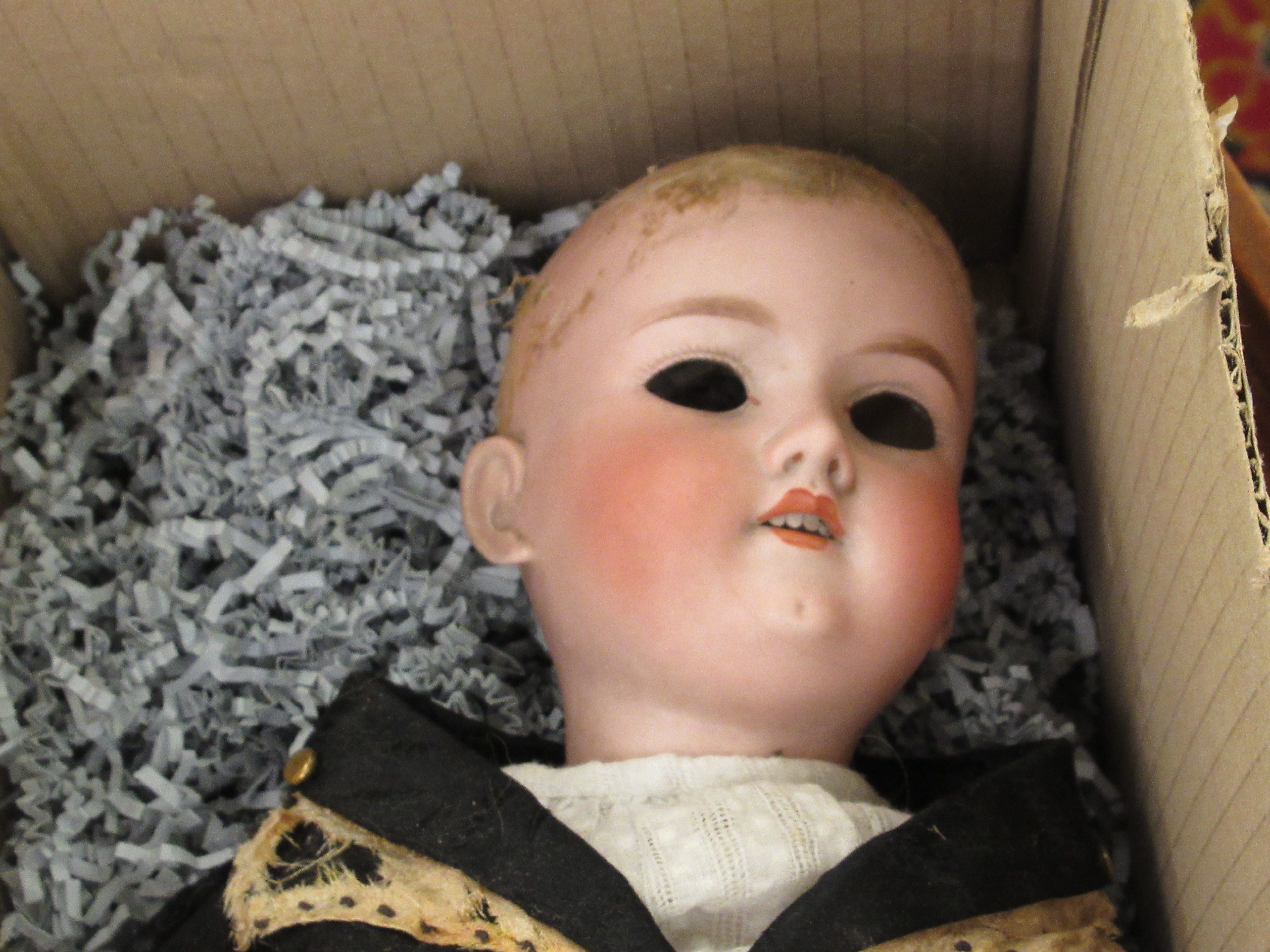 An early 20thC bisque head doll with mobile composition limbs,