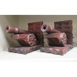 A pair of mid 20thC stained wooden bookends, fashioned as canons,