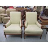A pair of Wesley Barrel stained beech showwood framed chairs with high, scrolled backs and enclosed,