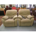 A pair of modern electrically operated recliner armchairs, upholstered in cushioned,