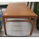 A 1980s teak coffee table, the top raised on square legs,
