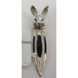 A silver bookmark with a rabbits head terminal 11