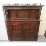 An early 20thC stained oak court cupboard with two doors behind pillar supports,
