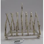 A silver plated six division toastrack, fashioned as crossover rifles,