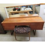 A 1970s teak kneehole five drawer dressing table, surmounted by a mirror,