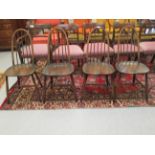 A set of four dark stained Ercol high hoop and spindled back chairs,