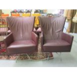 A pair of modern 'vintage' style wingback chairs, having enclosed arms,