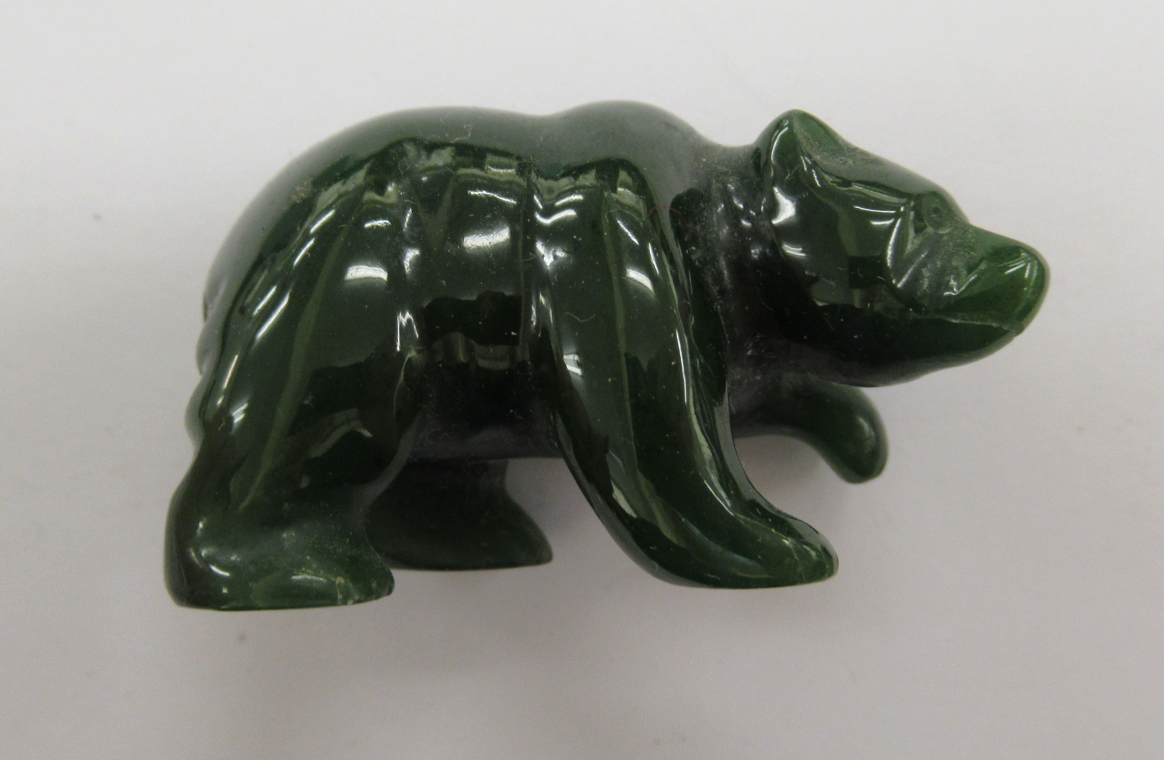 A carved dark green hardstone model bear 2''L 11