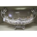 A silver coloured metal table centrepiece of navette form with opposing, high, scrolled handles,