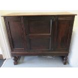 An 18thC and later oak cabinet with a plank constructed top, over a panelled door,