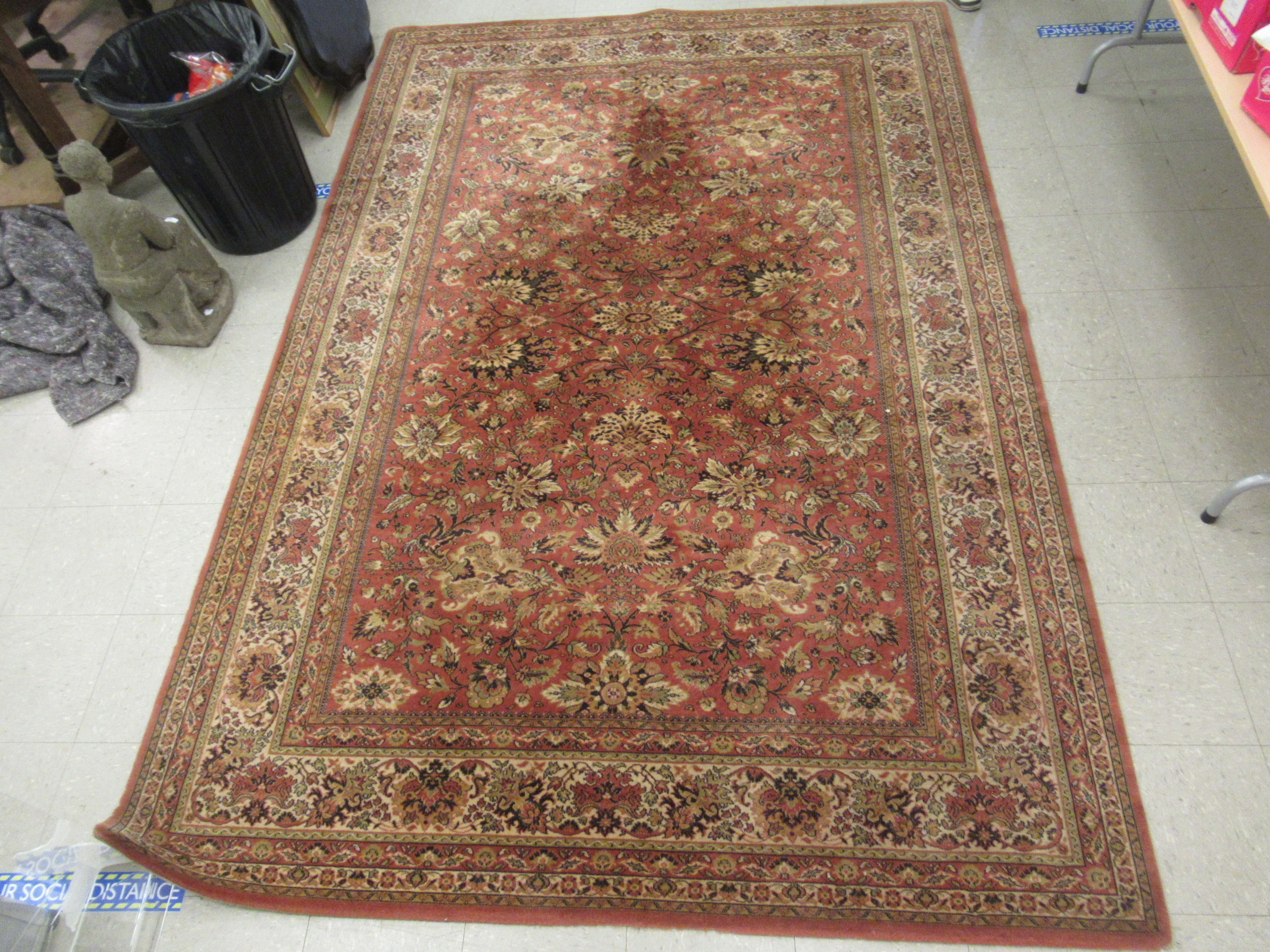 A Belgian rug with floral motifs on an iron red ground 120'' x 78'' LAM