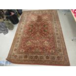 A Belgian rug with floral motifs on an iron red ground 120'' x 78'' LAM