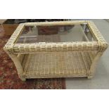 A modern conservatory coffee table, the insert bevelled glass top in a cream painted wicker frame,