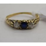 An 18ct gold ring, set with a central sapphire,