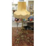 A modern 'antique' inspired brass standard lamp with a reeded and twist column, on a cherubic,