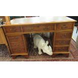 A modern yew finished twin pedestal desk, the top set with a tooled brown hide scriber,