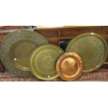 20thC brass and copper chargers and trays: to include a Persian example with engraved decoration