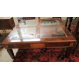 A modern mahogany and walnut finished coffee table with four plate glass panelled top,