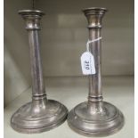 A pair of loaded silver candlesticks, each having a detachable sconce, in a cylindrical stem,