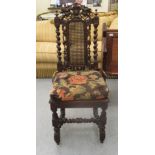 A 19thC profusely carved and barleytwist turned oak framed hall chair with a woven split cane back