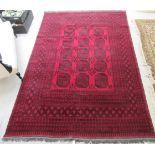A Persian rug, decorated with repeating floral and other designs,